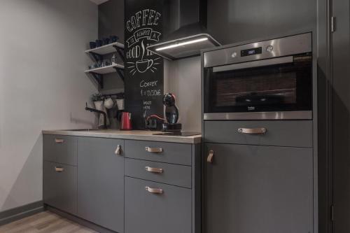 a kitchen with stainless steel appliances and a blackboard at S7 Apartment in Rīga