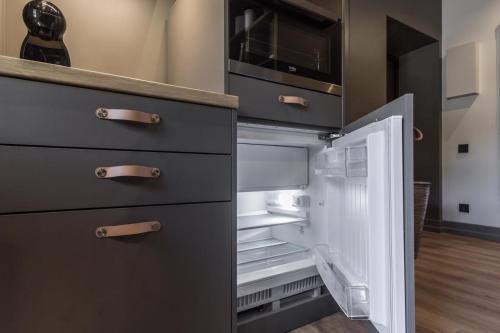 an empty refrigerator with its door open in a kitchen at S7 Apartment in Rīga