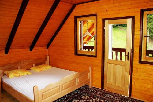 una camera con un letto in una baita di tronchi di Triangle Woodhouse a Plav