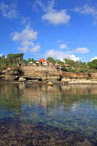 a body of water with a group of people on the shore at Twilight Ceningan in Nusa Lembongan