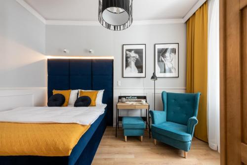 una camera con letto e sedia blu di Apartament Francuski a Breslavia