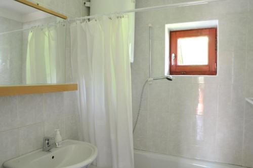 y baño con cortina de ducha y lavamanos. en Architect’s house - peaceful and minimalistic, en Bled