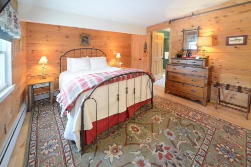 1 dormitorio con 1 cama en una habitación con paredes de madera en The Springwater Bed and Breakfast, en Saratoga Springs