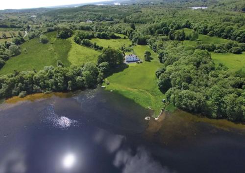 an aerial view of a lake with a house at Andresna House in Corrigeenroe