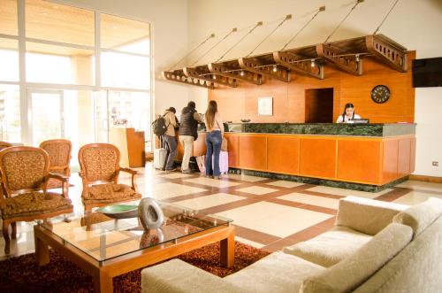 a lobby with a bar with people standing in it at Hotel Diego De Almagro Arica in Arica