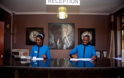 two men standing at a table in a restaurant at Tulia Boutique Hotel & Spa in Arusha