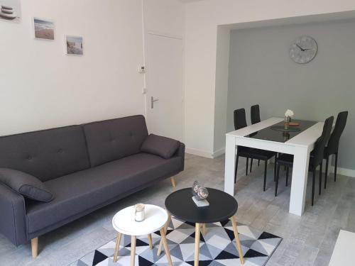 ein Wohnzimmer mit einem Sofa und einem Tisch in der Unterkunft Le cosy d’Amboise in Amboise