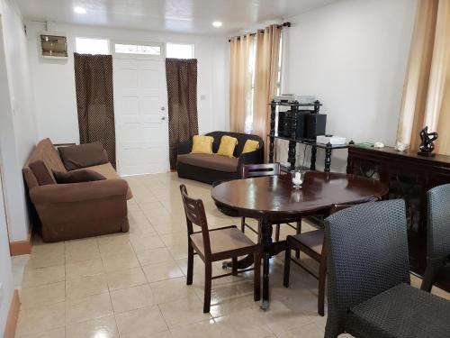 a living room with a table and chairs and a couch at Midway Cottage in Scotts Head Village