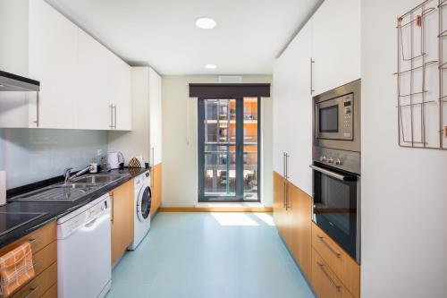a kitchen with a sink and a dishwasher at OCEANFRONT: Luxury Magnificent Views and Pool in Olhão