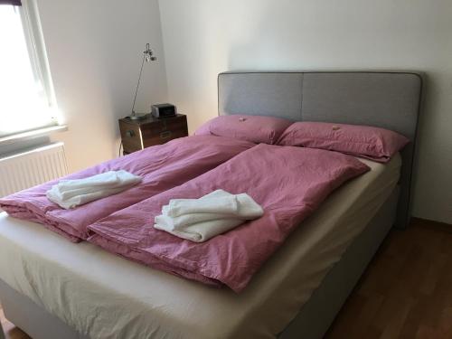 - un lit avec 2 serviettes blanches dans l'établissement Ferienwohnung über dem Ilmpark, à Weimar