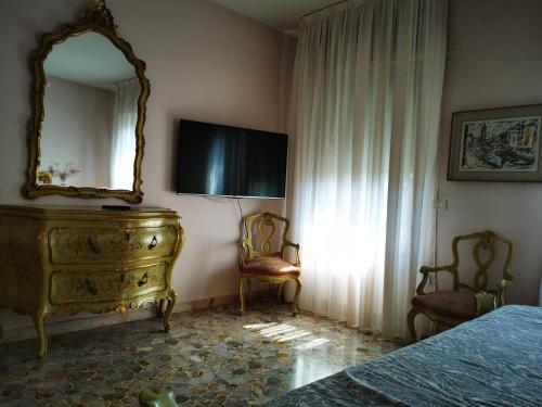 una camera con cassettiera, specchio e letto di Cà ARIVANLIAL Venice villa apartament a Lido di Venezia