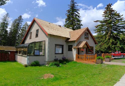 a small house with a porch and a yard at Riverfront Estate Bed&Breakfast Banff in Banff