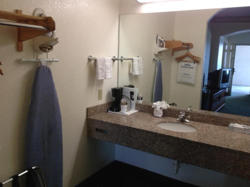 a bathroom with a sink and a mirror at HomeBridge Inn and Suites in Beaumont