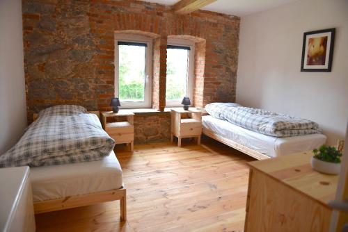 a room with two beds and a brick wall at Ferienhof Uckermark am Oberuckersee in Suckow