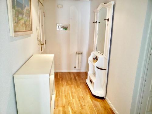 a kitchen with a white refrigerator and a wooden floor at Roxy 1 in Ávila