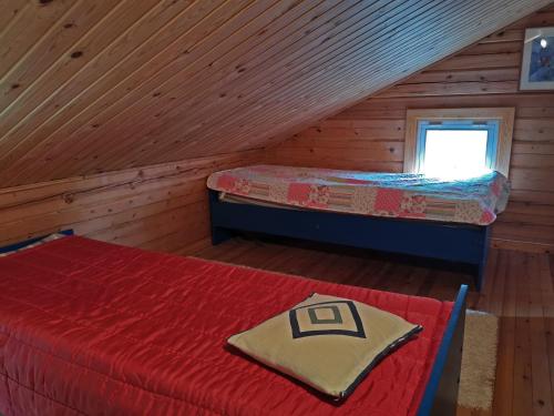 a bedroom with two beds in a log cabin at Pistoretki Toivakka in Toivakka