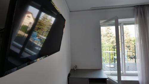 a flat screen tv hanging on a wall next to a window at Anna Villa Füred Boutique Rooms in Balatonfüred