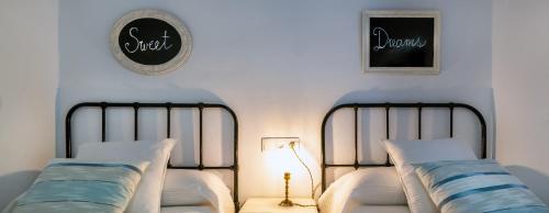 a bedroom with two beds and a clock on the wall at Casa Tita María in Bubión