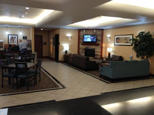 a lobby of a hotel with a living room and dining room at Super 8 by Wyndham Odessa TX in Odessa