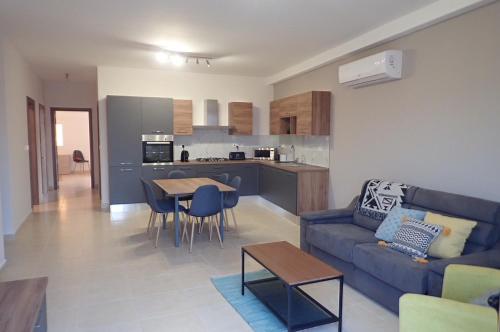 a living room with a couch and a table and a kitchen at Rabat Falcon Apartment in Rabat