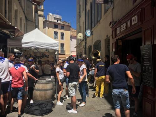 a group of people walking down a street with a barrel at Appart sympa Nimes centre in Nîmes