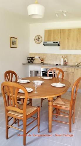 une cuisine avec une table et des chaises en bois dans l'établissement Rose cottage, à Pontrieux