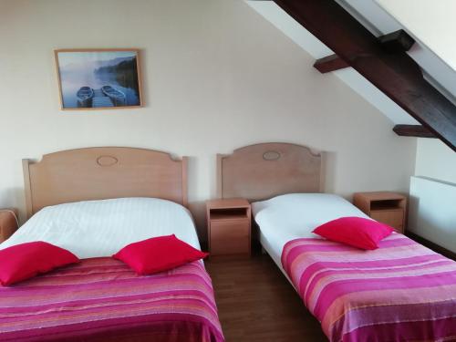 two beds sitting next to each other in a bedroom at Vue sur la Rance in Saint-Samson-sur-Rance