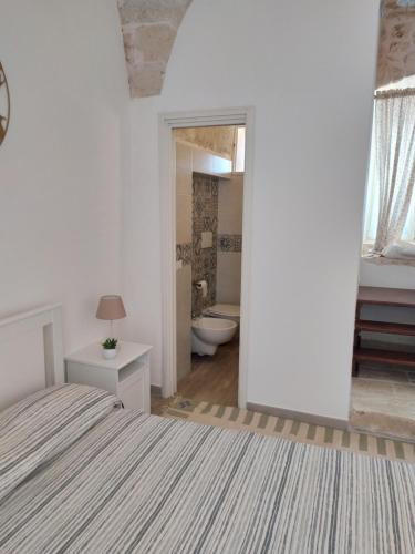 une chambre blanche avec un lit et une salle de bain dans l'établissement LA CASETTA 6058, à Conversano