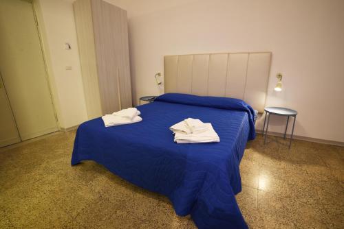 una camera da letto con un letto blu con sopra degli asciugamani di TIFEO Bed & Breakfast a Catania
