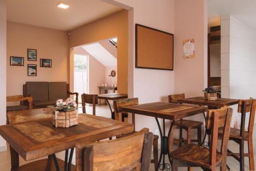 uma sala de jantar com mesas e cadeiras de madeira em Pousada Moquirido em Florianópolis