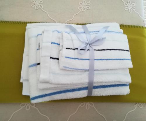 a stack of towels with a bow on top at Casal Mala-Posta in Rio Maior