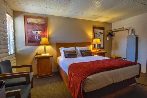 a hotel room with a bed and a chair at Rustic Inn in Moab