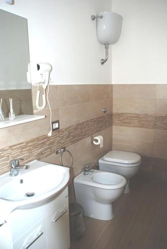 a bathroom with a sink and a toilet and a mirror at Binario 2 in San Giorgio a Cremano