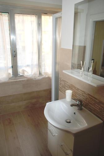 a bathroom with a white sink and a window at Binario 2 in San Giorgio a Cremano