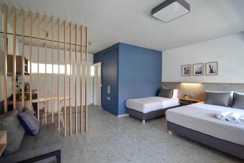 1 dormitorio con 2 camas y pared azul en Voula Seaside Apartments en Kallithea Halkidikis