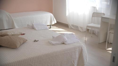 a bedroom with two beds with white sheets and towels at Binario 2 in San Giorgio a Cremano