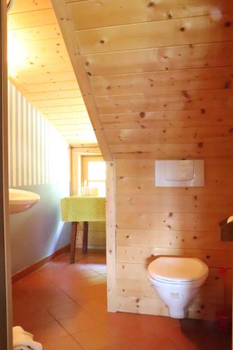 a bathroom with a toilet in a wooden wall at Traunsee-Traum in Grasberg