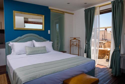 a bedroom with a bed with a blue wall at Acropolis Eye Loft in Athens