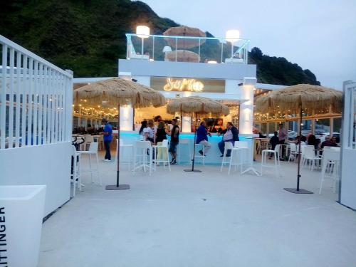 a white building with tables and chairs and umbrellas at Laredo Ocean Port in Laredo