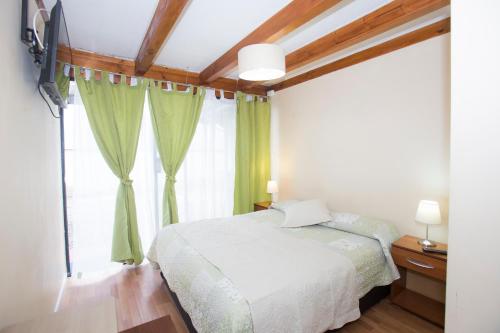 a bedroom with a bed and a large window at Hostal Ravello - ex Viña Bella in Viña del Mar