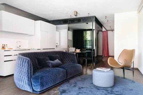 un soggiorno con un divano blu e una cucina di United Places Hotel Botanic Gardens a Melbourne