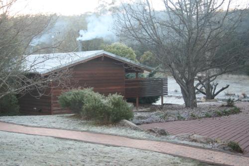 a wooden cabin with a bench in front of it at Granite Belt Retreat and Brewery in Stanthorpe