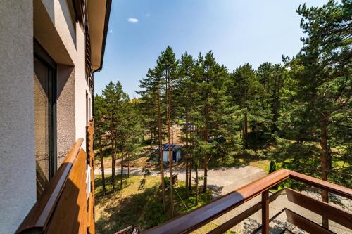 a balcony with a view of the woods at LUX apartman u vili Pekovic in Zlatibor