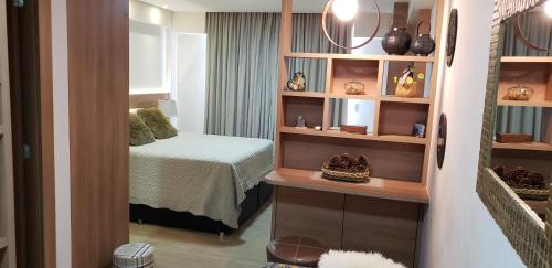 Pokój z sypialnią z łóżkiem i półkami w obiekcie Flat em Pedra Azul w mieście Pedra Azul