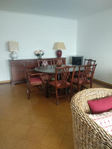 a living room with a table and chairs and a couch at Lila Ocean View Apartment in Ponta Delgada