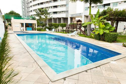 una piscina de agua azul en un edificio en VERANO PONTA NEGRA AP1807, en Natal