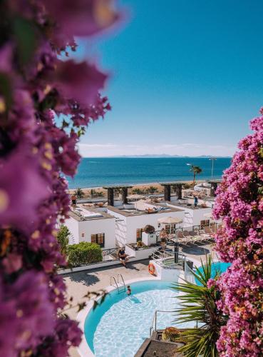 a view of a resort with a swimming pool and the ocean at Apartamentos Moraña in Puerto del Carmen