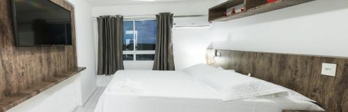 1 dormitorio con 2 camas y TV de pantalla plana en VERANO PONTA NEGRA AP1807, en Natal