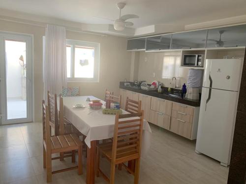 een keuken met een tafel en stoelen en een koelkast bij Casa condominio fechado Arraial D’ajuda in Arraial d'Ajuda