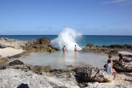 a group of people in the water at the beach at BlueDreamVacances Marines IV in Saint-François